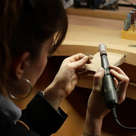 Photo du travail de ponçage durant l'atelier créer son pendentif.