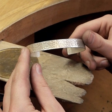 Photo des mains qui travaillent le bracelet en argent lors de l'atelier créer son bracelet.