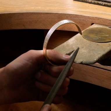 Photo d'un focus sur les mains qui poncent lors de l'atelier créer son bracelet.
