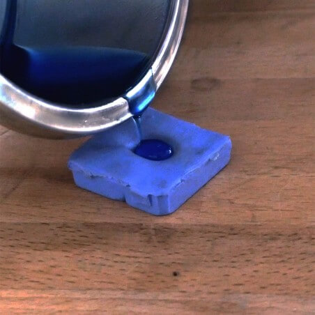 Photo de la cire liquide versée dans le moulage de l'empreinte lors de l'atelier bijou empreinte bébé.