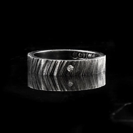 Photo de l'alliance homme avec diamant blanc modèle tungstène sur fond marbre noir vue de face.