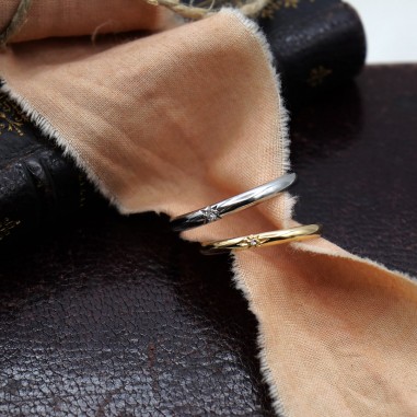 Deux alliances étoile présentées sur un tissu léger.