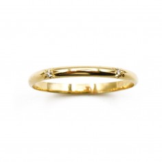 Photo d'une alliance étoile en or jaune 18k sur fond blanc vue de dessus..