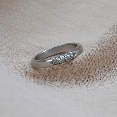 Photo d'une alliance étoile avec 7 diamants sur fond tissu.