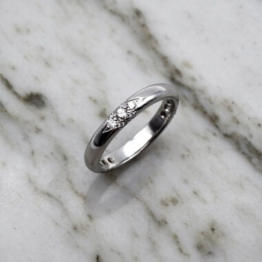 Photo d'une alliance étoile sur fond marbre blanc vue de dessus.