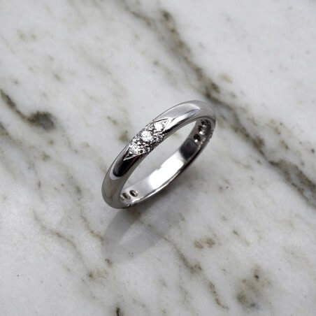 Photo d'une alliance étoile sur fond marbre blanc vue de dessus.