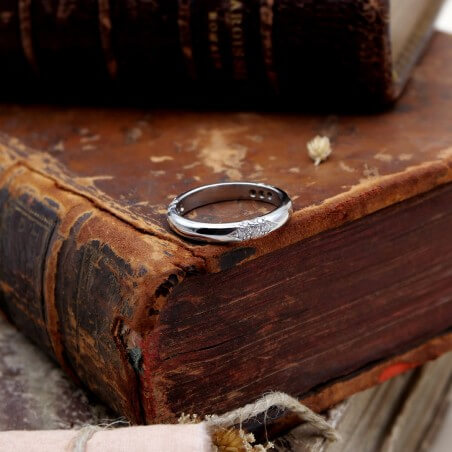 Photo d'une alliance étoile 21 diamants sur fond livre de messe vue de devant.