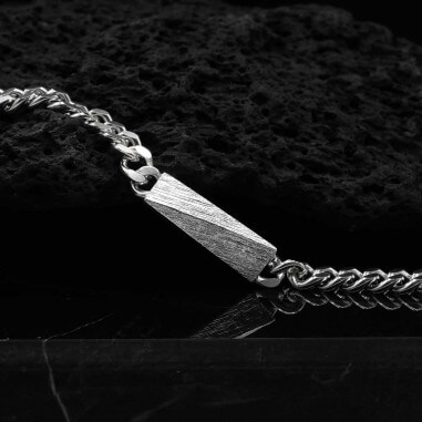 Photo sur fond lave noire de la gourmette homme en argent modèle Tungstène avec détail de la texture