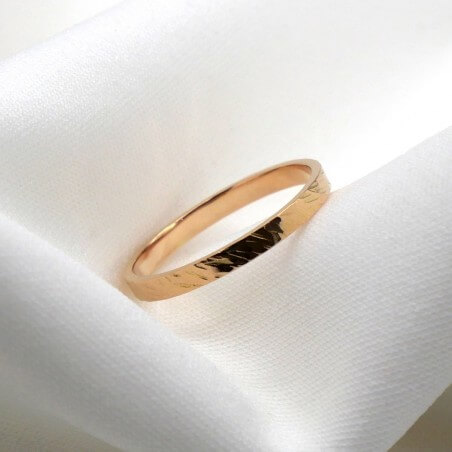 Photo sur fond tissu blanc alliance ruban or rose modèle Encelade largeur 2 mm vue de côté.