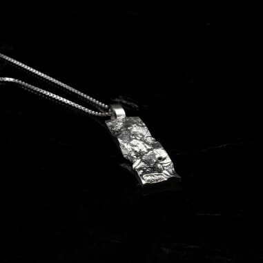 Photo sur fond lave noire du collier diamant homme modèle A76 finition polie avec détail de la texture.