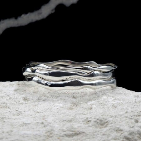 Photo mood sur une pierre blanche des joncs en argent modèle Halo.