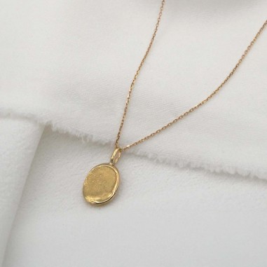 Photo sur fond tissu blanc du pendentif créer lors de l’atelier bijou empreinte bébé.