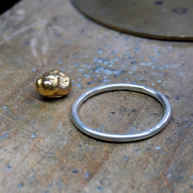 Photo de la pépite d'or et de l'anneau qui seront assemblée à l'atelier créer sa bague de divorce.