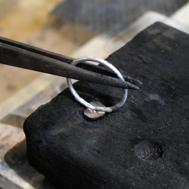 Soudure de la pépite d'or sur le corps de bague lors de l'atelier créer sa bague de divorce.