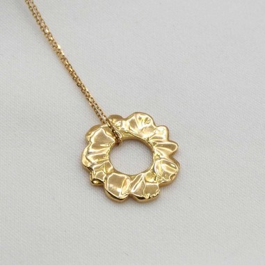 Photo sur fond tissu blanc du collier soleil or.