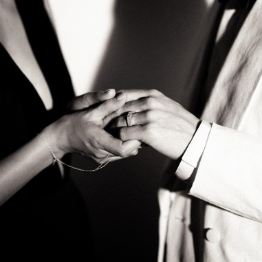 Photo noir et blanc des mains d’un couple qui porte l’alliance originale homme modèle Hyperion L.