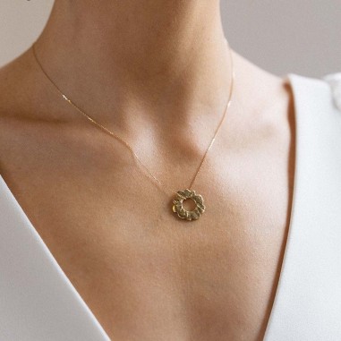 Zoom photo portée avec une robe de mariée du pendentif soleil or.