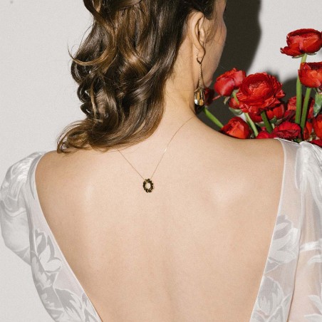 Photo portée dans le cou du pendentif soleil or.