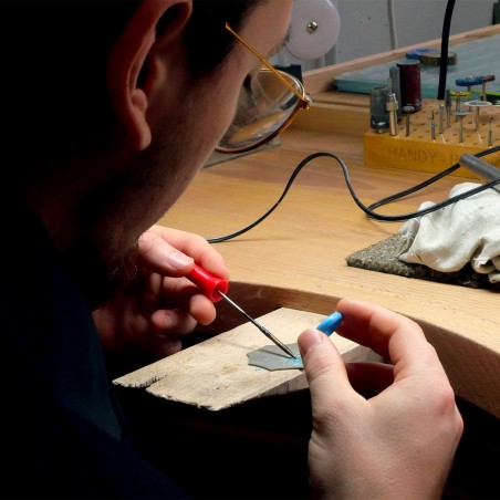 Photo des mains à l'œuvre en train de chauffer une bague en cire lors de l'atelier créer son alliance empreinte digitale à Rouba