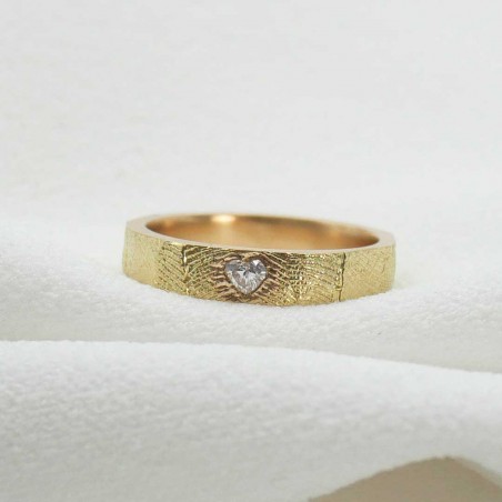 Photo fond tissu blanc d’une alliance diamant en or jaune fabriquées lors de l'atelier créer son alliance empreinte digitale à R