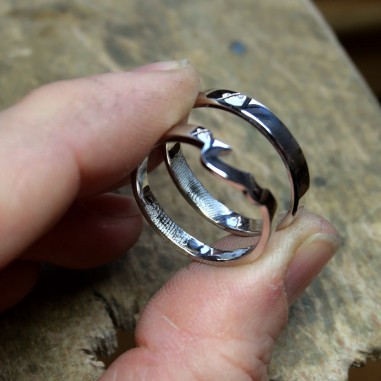  Photo dans les mains de deux alliances en or gris fabriquées lors de l'atelier créer son alliance empreinte digitale à Roubaix,