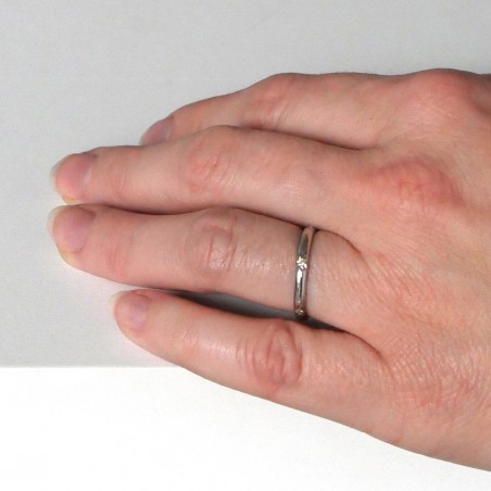 Photo d'une main de femme portant l'alliance étoile en or blanc modèle Taygète.