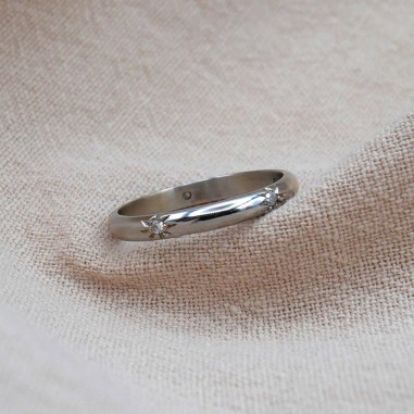Photo d'une alliance étoile en or blanc 18k sur fond sur tissu.