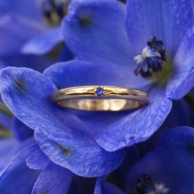 Photo sur fond blanc de l’alliance en saphir bleu modèle Électre dans une fleur.