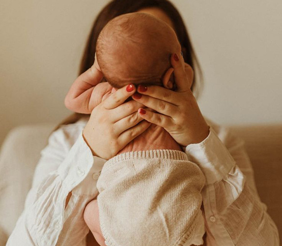 Un b&eacute;b&eacute; de dos, tenue par sa mere, pierre de naissance.